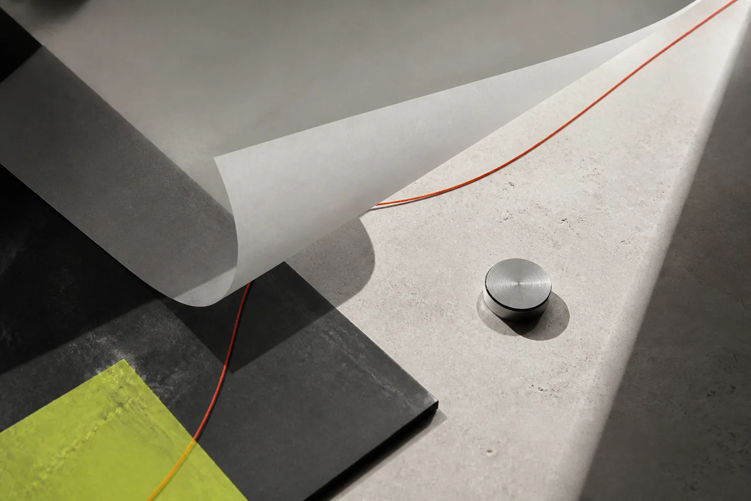 Folded paper on a worktable with a thin red line across it