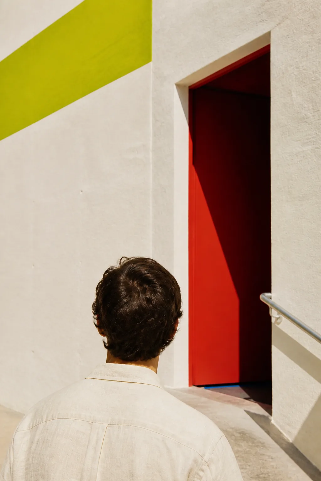 A figure facing an open architectural threshold